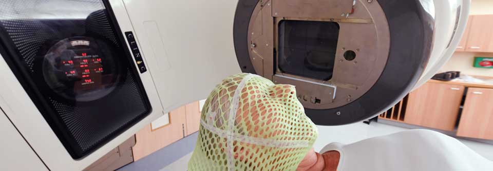 Diese Patientin erhält wegen ihres Hirntumors eine Strahlentherapie. Mit dem grünen Netz wird ihr Kopf in einer fixen Position gehalten.