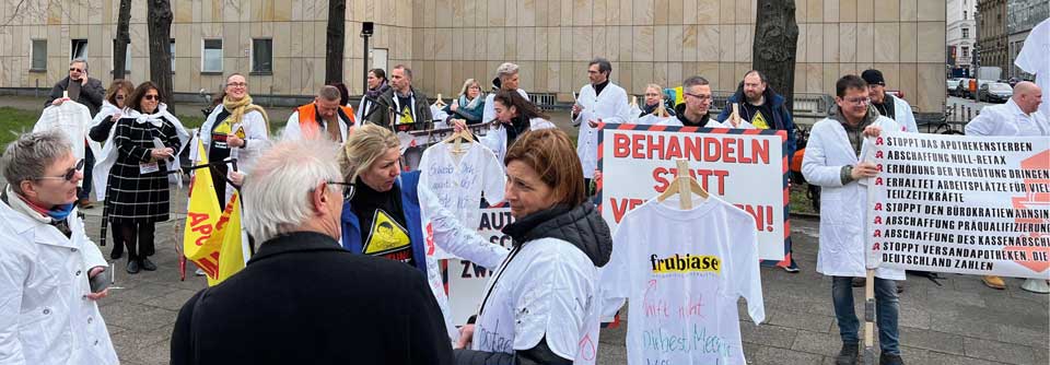 Eine Gruppe von Ärzten, Apothekern und Therapeuten versammelte sich am 29. März in Berlin, um Kittel an das Tor des Bundesgesundheitsministeriums zu hängen.