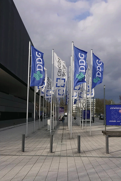 Auf dem Vorplatz der Messe Berlin wehen die Fahnen der Deutschen Dermatologischen Gesellschaft e.V. (DDG) und der Messe Berlin.